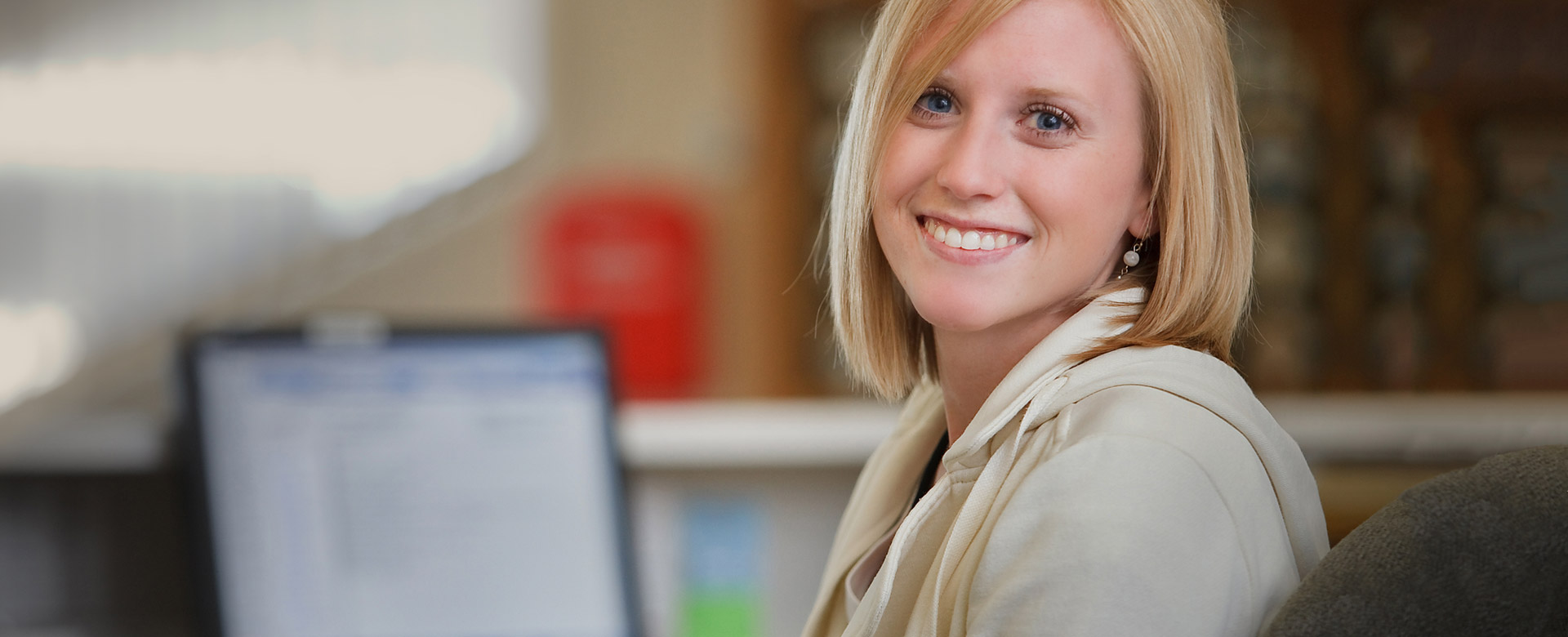  Photo of a woman sitting at her desk smiling 