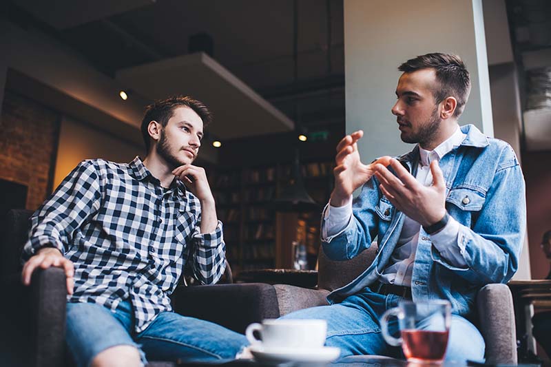 Two men having a conversation to set healthy boundaries.