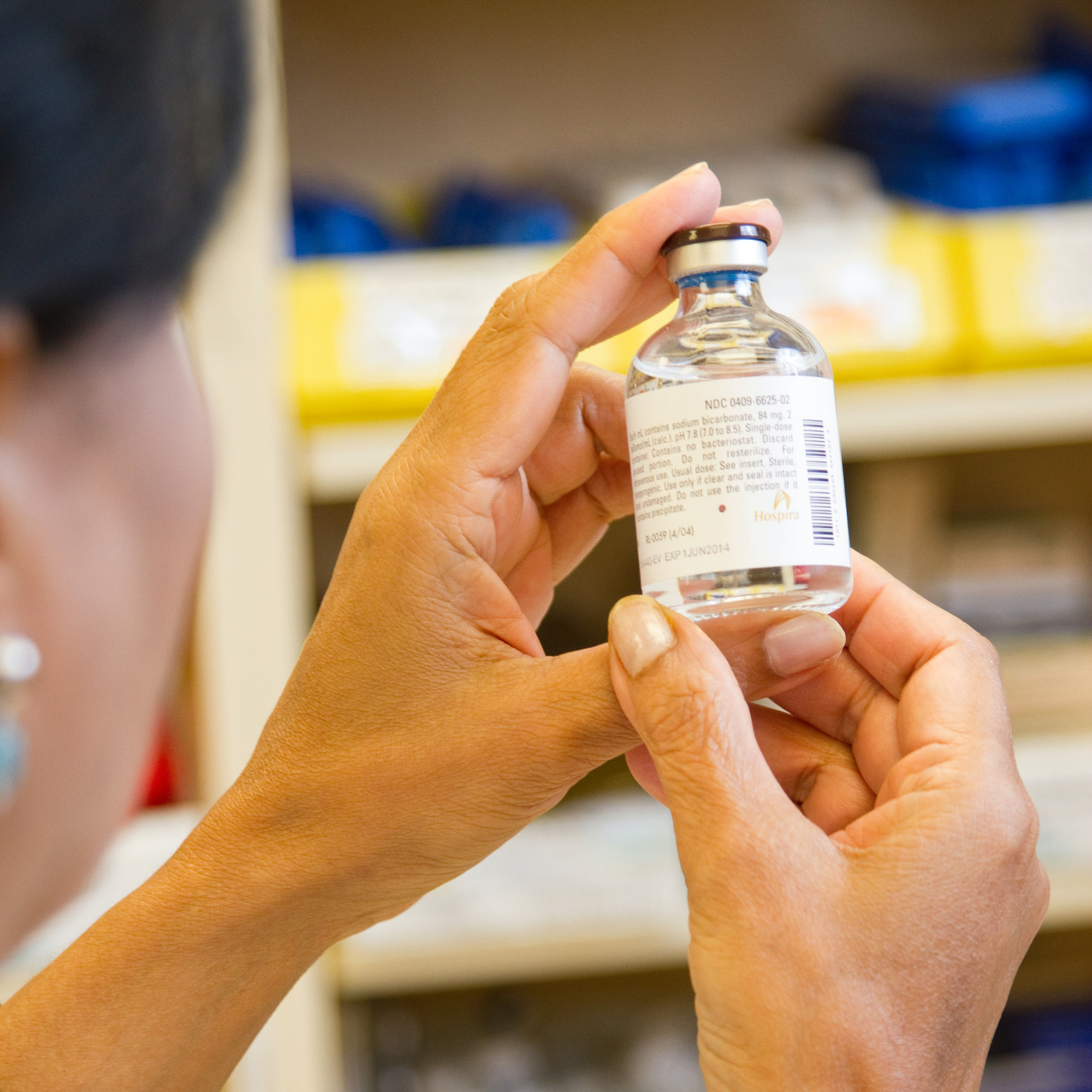 Female pharmacist holding a drug vial